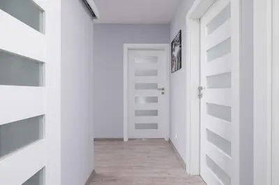 a hallway with white walls and a white door at Cracow Prądnik Spacious & Family Apartment with 3 bedroom by Renters Prestige in Kraków
