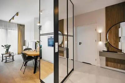 a kitchen and dining room with a table and a glass wall at Golden Dreams Luxury Apartments 21 in Kraków