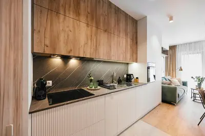 a kitchen with wooden cabinets and a counter top at Golden Dreams Luxury Apartments 21 in Kraków
