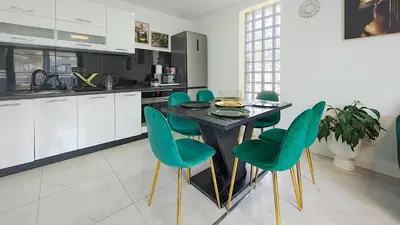 a kitchen with a black table and green chairs at Wlodarska 4a Lux Premium in Kraków