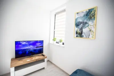 a living room with a tv on a white wall at Wlodarska 4a Lux Premium in Kraków