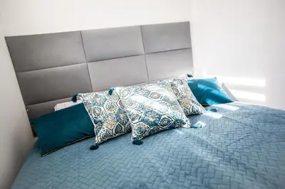 a bed with four pillows on top of it at Wlodarska 4a Lux Premium in Kraków