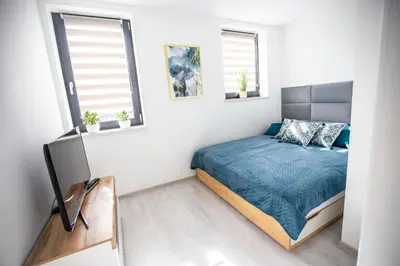 a bedroom with a bed and two windows at Wlodarska 4a Lux Premium in Kraków