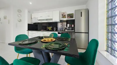 a kitchen with a black table and green chairs at Wlodarska 4a Lux Premium in Kraków