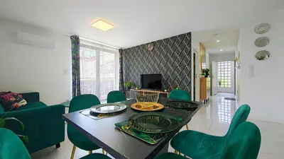 a living room with a table and green chairs at Wlodarska 4a Lux Premium in Kraków