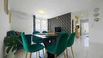 a dining room with a table and green chairs at Wlodarska 4a Lux Premium in Kraków