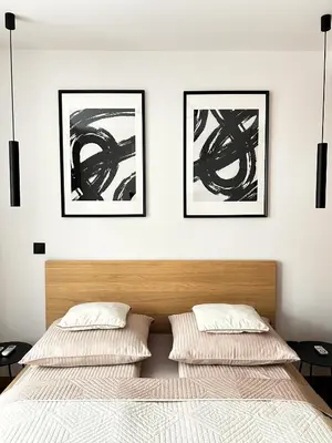 two beds in a bedroom with three pictures on the wall at Kalwa Nest Stare Podgórze in Kraków