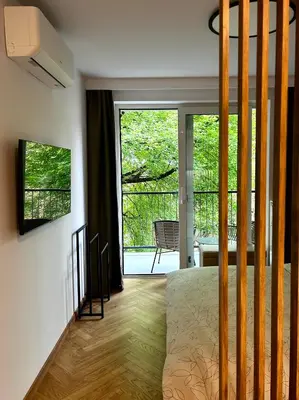 a bedroom with a bed and a sliding glass door at Kalwa Nest Stare Podgórze in Kraków
