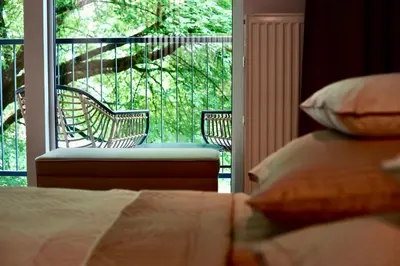 a room with a balcony with two chairs and a bed at Kalwa Nest Stare Podgórze in Kraków