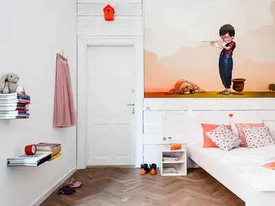 a room with a bed and a wall with a painting of a child holding at Boom Apartments in Kraków