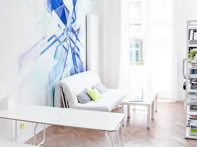 a living room with a white couch and a painting at Boom Apartments in Kraków
