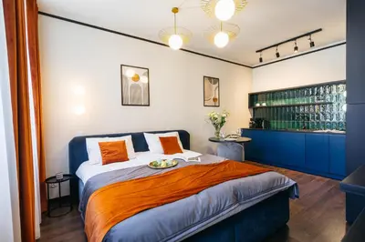 a bedroom with a large bed with orange pillows at Estery12 in Kraków