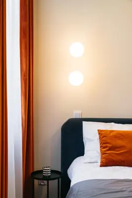 a bedroom with a bed with an orange pillow on it at Estery12 in Kraków