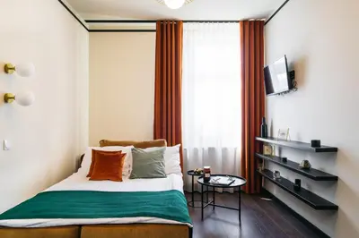 a small bedroom with a bed and a television at Estery12 in Kraków