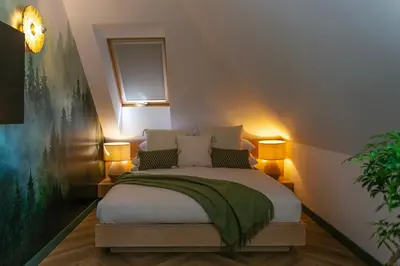 a bedroom with a bed with a green blanket on it at Lisie Sprawki in Bebło