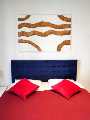 a bedroom with two red pillows and a painting at Romantica SPA Kraków in Kraków