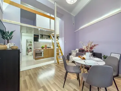 a living room with a table and chairs and a kitchen at Apartament przy Rynku Długa 23 in Kraków