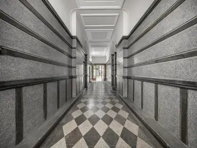 an empty corridor with a checkered floor in a building at Apartament przy Rynku Długa 23 in Kraków