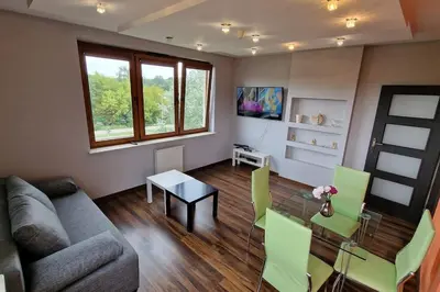 a living room with a couch and a table at Rodzinny apartament dla sześciu osób z parkingiem prywatnym in Kraków