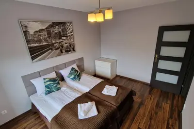 a bedroom with a bed and a picture on the wall at Rodzinny apartament dla sześciu osób z parkingiem prywatnym in Kraków