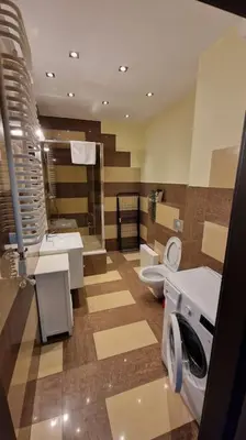 a bathroom with a toilet and a sink and a washing machine at Rodzinny apartament dla sześciu osób z parkingiem prywatnym in Kraków