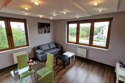a living room with a couch and a table at Rodzinny apartament dla sześciu osób z parkingiem prywatnym in Kraków