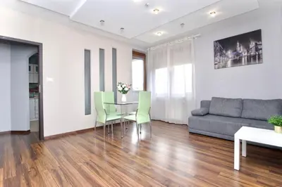 a living room with a glass table and a couch at Rodzinny apartament dla sześciu osób z parkingiem prywatnym in Kraków