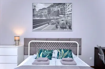a bedroom with a white bed and a picture on the wall at Rodzinny apartament dla sześciu osób z parkingiem prywatnym in Kraków