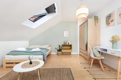 a bedroom with a bed and a table and a desk at Pastel Grove Suite - by Upstairs in Kraków