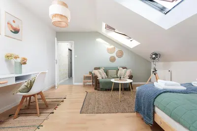 a bedroom with a bed and a couch and a table at Pastel Grove Suite - by Upstairs in Kraków