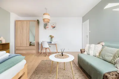 a living room with a couch and a table at Pastel Grove Suite - by Upstairs in Kraków
