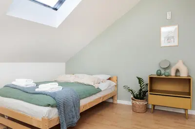 a bedroom with a bed and a wooden dresser at Pastel Grove Suite - by Upstairs in Kraków