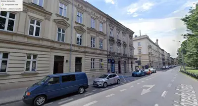 a street with cars parked next to a building at Apartment near Old Town in Kraków