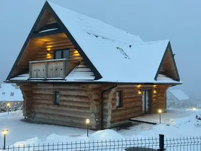 a log cabin in the snow with a roof at Domek w górach z balią jacuzzi Asina Chata Zawoja in Zawoja
