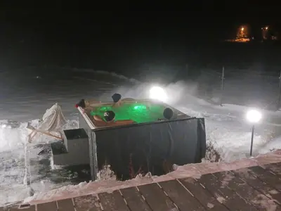 a bath tub covered in snow at night at Domek w górach z balią jacuzzi Asina Chata Zawoja in Zawoja