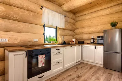 a kitchen with wooden walls and a refrigerator at Domek w górach z balią jacuzzi Asina Chata Zawoja in Zawoja