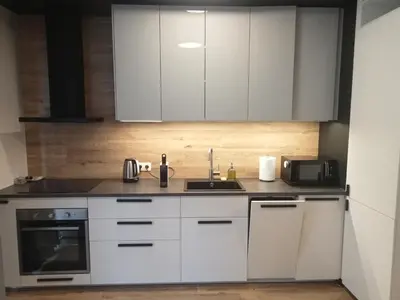 a kitchen with white cabinets and a sink at Like Home Apartments in Kraków