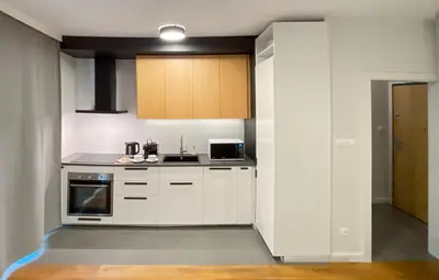 a kitchen with white cabinets and a stove at Like Home Apartments in Kraków
