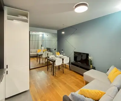 a living room with a white couch and a dining room at Like Home Apartments in Kraków