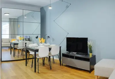 a dining room with a table and a television at Like Home Apartments in Kraków