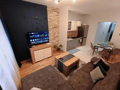 a living room with a couch and a table and a tv at Seventh House in Kraków