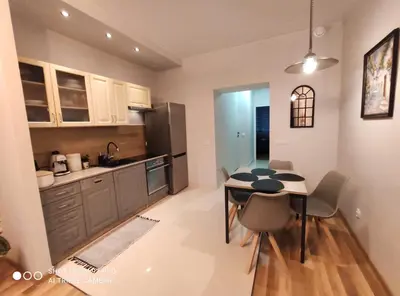 a kitchen with white cabinets and a stainless steel refrigerator at Seventh House in Kraków