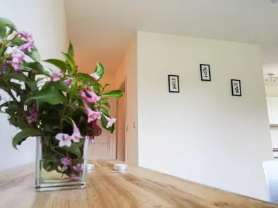 a vase of flowers sitting on a wooden table at Apartament Hubertus in Bochnia