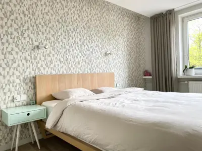 a bedroom with a white bed and a window at Z widokiem na Wisłę in Kraków