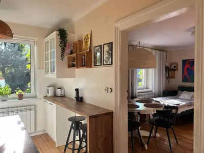 a kitchen and living room with a table and a dining room at Apartament na starej Krowodrzy in Kraków