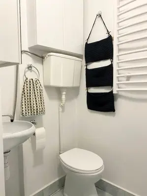 a white bathroom with a toilet and a sink at Apartament na starej Krowodrzy in Kraków