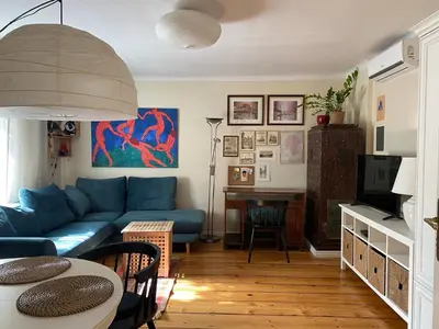 a living room with a blue couch and a table at Apartament na starej Krowodrzy in Kraków