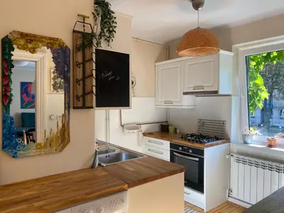 a kitchen with white cabinets and a sink and a window at Apartament na starej Krowodrzy in Kraków