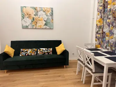 a living room with a green couch and a table at Apartament Stare Miasto in Kraków