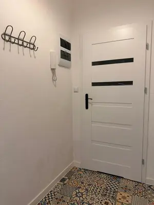 a hallway with a white door and a tile floor at Apartament Stare Miasto in Kraków